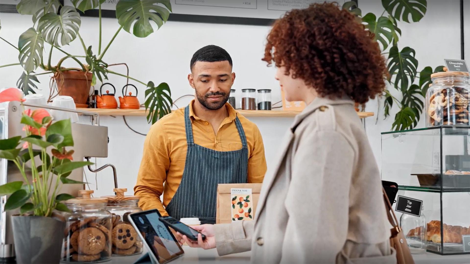 Customer making payments using a mobile phone at a merchant store
