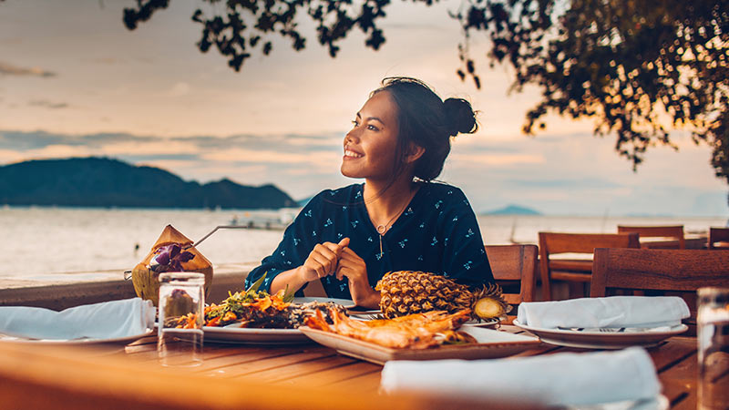 lady having dinner gazing into the sunset