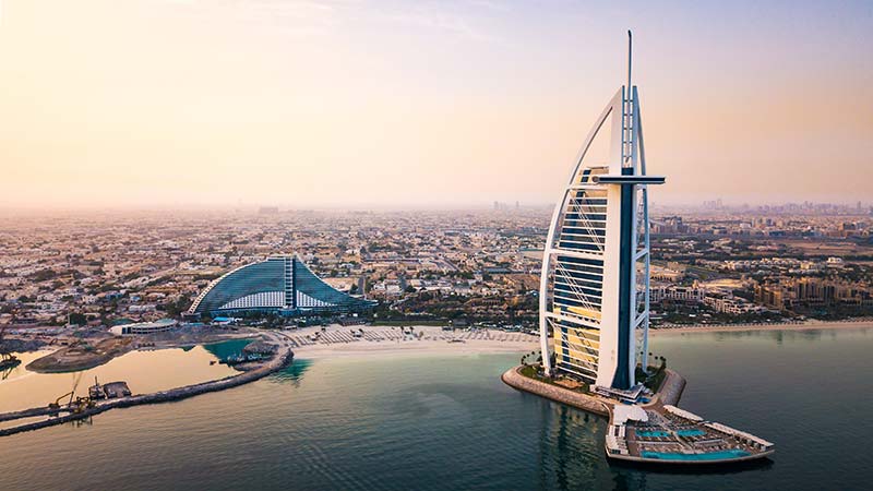 Dubai seaside skyline and Burj Al Arab luxury hotel aerial view at sunrise