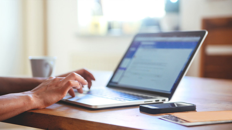 hands typing on a laptop